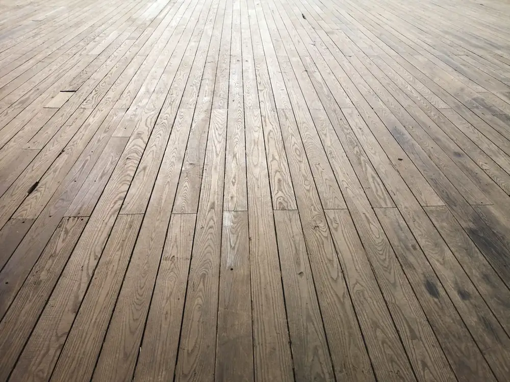 Parquet desgastado con el barniz apagado y las lamas grisáceas antes de acuchillar