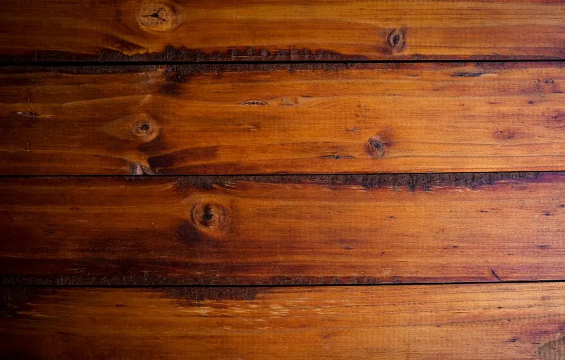 Parquet restaurado con barniz nuevo, tono cálido y acabado brillante tras el acuchillado